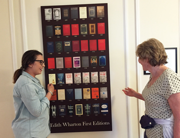 Our guide Cecily shows Heidi the Poster of Edith Wharton's 40 first editions