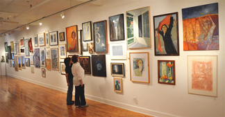 Two visitors viewing The National Association of Women Artists' 123rd Annual Exhibit at the Sylvia Wald - Po Kim Gallery in NYC